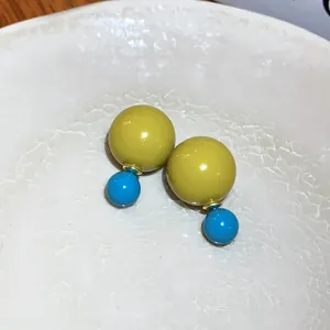 Detailansicht der bonbonfarbenen Doppelball-Ohrstecker mit gelben und blauen Kugeln.