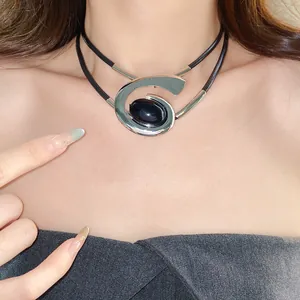 Gedetailleerde opname van een minimalistische geometrische spiraal choker met zwarte steen
