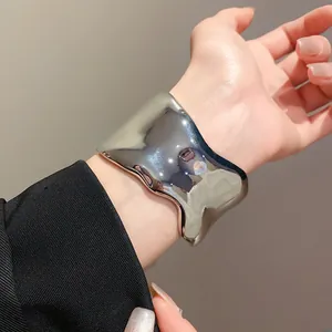 Brazalete ancho irregular de metal plateado brillante con acabado de espejo moderno y minimal
