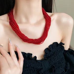 Macro shot of a vintage multi-strand red beaded necklace worn on neck and collarbone