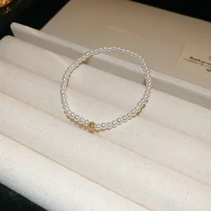 Detailed close-up of a vintage French style pearl bracelet with a textured gold bead on display