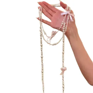 Elegante collana di perle lunga in stile francese con fiocchi di nastro a pois rosa.