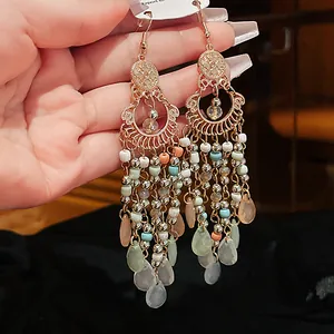 Close-up of Bohemian long tassel earrings with colorful beads and translucent teardrop pendants.