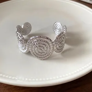 Unique textured silver open cuff bracelet featuring elegant spiral pleated circular motifs