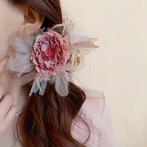 Elegante fermaglio per capelli con fiore rosa e piume per un look in stile foresta