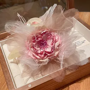 Elegante molletta per capelli a fiore rosa con piume morbide in una scatola regalo di legno