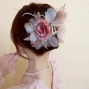 Elegante molletta per capelli con fiore rosa e piume per un'acconciatura raccolta chic