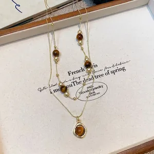 Elegant vintage tiger's eye beaded layered necklace in golden finish with round pendant
