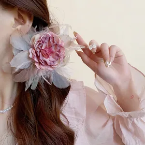 Dettaglio ravvicinato dell'elegante molletta a fiore rosa con piume delicate e soffici.