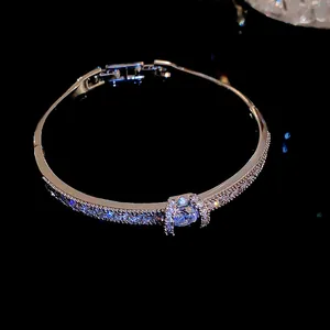 Elegant silver bangle with sparkling zircon stones and a prominent center gem detail.