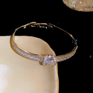 Detailed view of elegant rose gold bangle encrusted with shimmering zirconia stones.