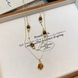 Detailed view of vintage tiger eye beaded double-layer necklace with gold pendant