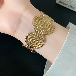 Detailed view of a golden textured circular spiral pattern open cuff bracelet for women