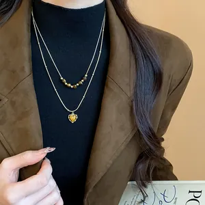 Close-up of retro double-layer tiger eye stone necklace featuring a heart-shaped pendant