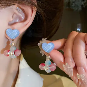 Close-up of blue heart-shaped earrings with colorful translucent glass bead clusters