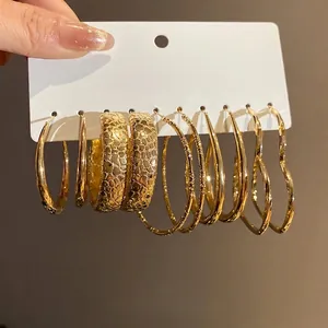Set of five pairs of vintage gold hoop earrings featuring heart shapes and textured patterns