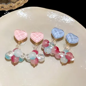 Detailed view of colorful glass heart earrings featuring delicate pastel bead clusters