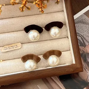 Close-up of elegant flocked velvet bow and pearl stud earrings in a jewelry box