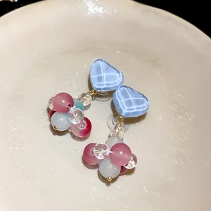 Detailed macro view of colorful glass bead earrings featuring a textured blue heart top