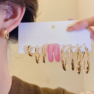 Close-up detail of stylish gold hoop and pink resin earring set on a display card.