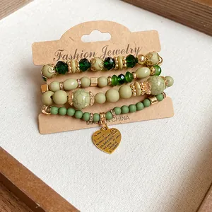 Detailed view of vintage green beaded bracelet set featuring a gold heart pendant