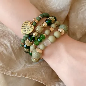 Detailed view of vintage green beaded layered bracelet with engraved heart charm