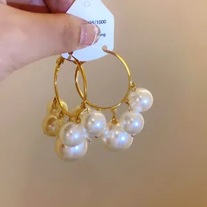 Detaillierte Nahaufnahme von Vintage-Goldohrringen mit weißen Perlenbüscheln