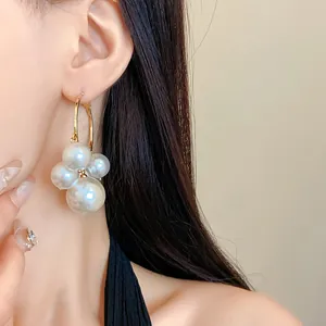 Nahaufnahme eleganter französischer Vintage-Perlenohrringe mit weißen Perlenbüscheln.