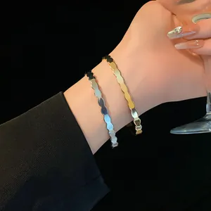 Elegant scalloped edge open bangles in gold and silver finishes worn on the wrist