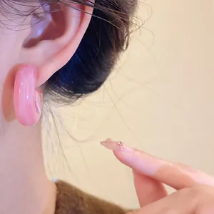 High-quality close-up detail of pink resin chunky C-shaped hoop earrings on ear