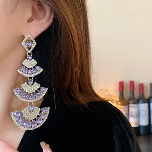 Primo piano di orecchini vintage a forma di ventaglio con cristalli viola e strass