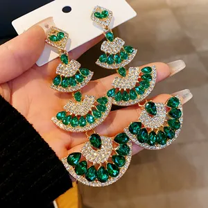 Dettaglio degli orecchini vintage a ventaglio in oro con strass verde smeraldo