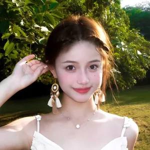 Elegant bohemian tassel earrings with shells worn by a model in outdoor sunlight
