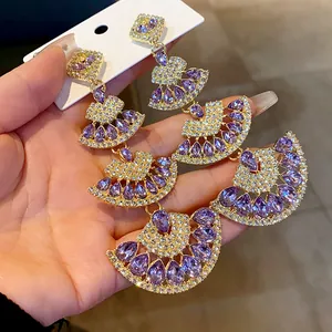 Primo piano di orecchini vintage a forma di ventaglio con cristalli viola e strass