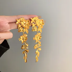 Elegant vintage style gold flower and leaf tassel drop earrings with a matte texture finish
