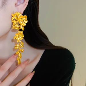 Detail view of elegant gold floral leaf tassel earrings with a vintage antique style finish.