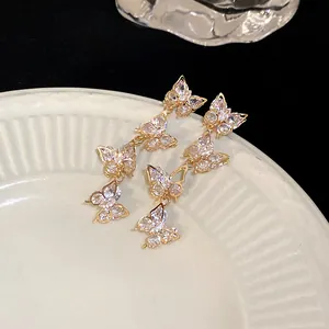 Detail view of elegant gold butterfly dangle earrings with sparkling cubic zirconia