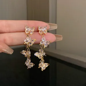 Macro view of elegant gold butterfly tassel earrings with cubic zirconia stones