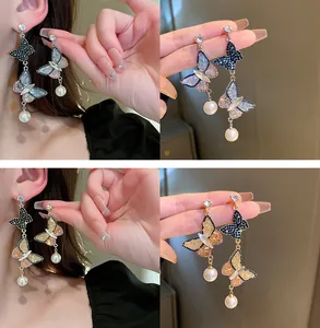 Gros plan de boucles d'oreilles papillon en cristal avec perles en bleu et doré