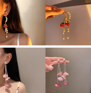 Détails de boucles d'oreilles élégantes avec perles, rose séchée et pétales