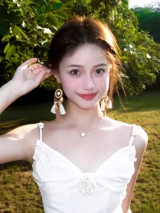 Close-up of bohemian white tassel earrings with shell charms on a model outdoors