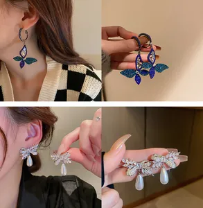 Détail collage de boucles d'oreilles élégantes en cristal papillon et perle sur un mannequin