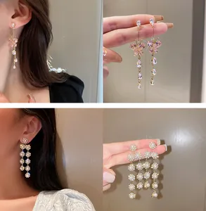 Collage de boucles d'oreilles papillon cristal et fleur perle sur modèle et en main