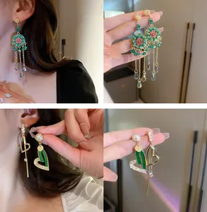 Détail de boucles d'oreilles vintage à pampilles roses et cœurs asymétriques en perles.
