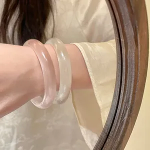Detailed macro shot of ice-clear resin round bangles in pink and white finishes