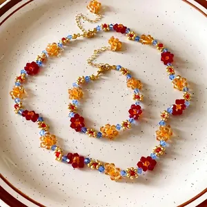 Set collana e bracciale con fiori di perline colorate con cristalli rossi, arancioni e blu