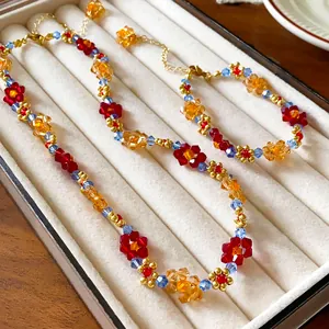 Primo piano di un set di collana e bracciale di perline colorate in un portagioie di velluto