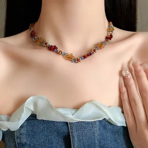 Vista dettagliata di una collana di perle colorate a forma di fiori sul collo.