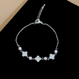 Detailed view of silver clover bracelet featuring sparkling zircons and white pearls