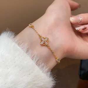 Detailed view of a gold-plated flower bracelet inlaid with zircons on a model's wrist